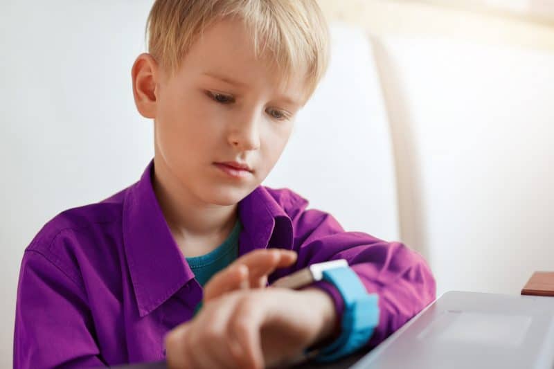 Child using smart watch on wrist.