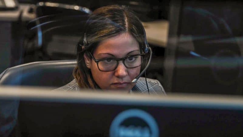 Close up of woman with headset looking at computer.